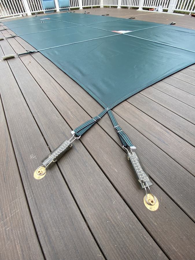 Cover straps and springs hooked to anchors in a composite deck.
